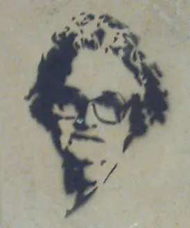 Een gespoten stencil van een man met bril en krullend haar op een lichte muur