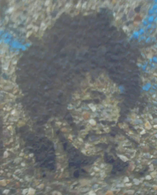 Een vaag stencil van een figuur met een bos haar op een ruwe kiezelmuur, met blauwe verfvlekken